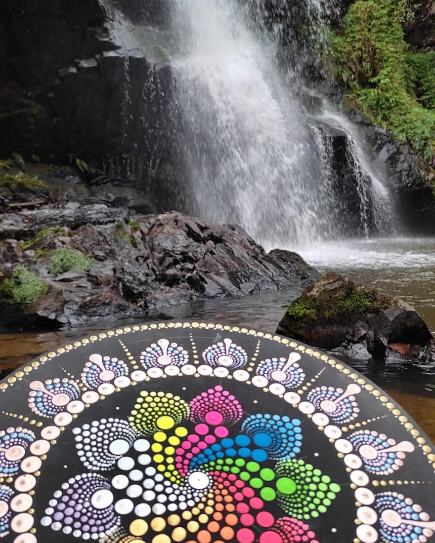 Mandala colorida em pontilhismo sobre cachoeira